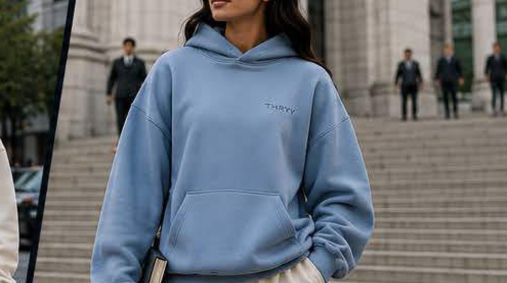 Woman walking up outdoor stairs in a Carolina Blue Thryv sweatshirt